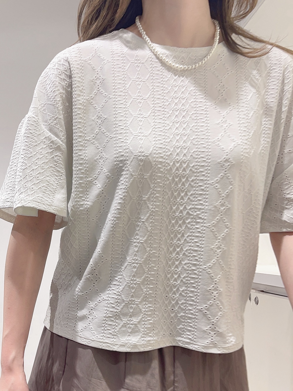 ホワイト系のTシャツ/カットソー、ブラウン系のスカート、シルバー系のネックレスを着用したレディースの夏コーディネートの5枚目の写真