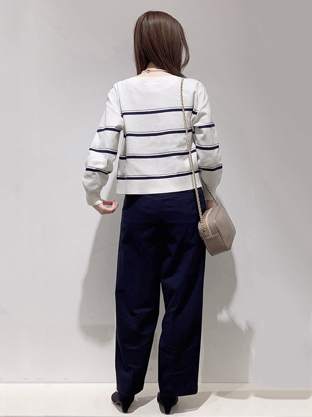 ホワイト系のニット/セーター、ブラック系のその他パンツ、グレー系のショルダーバッグを着用したレディースの春コーディネートの3枚目の写真