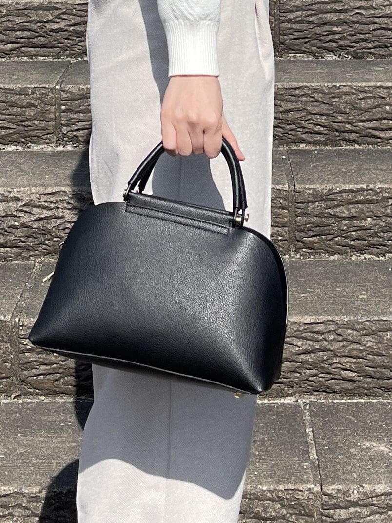 ホワイト系のニット/セーター、ベージュ系のその他パンツ、ブラック系のハンドバッグを着用したレディースの冬コーディネートの9枚目の写真