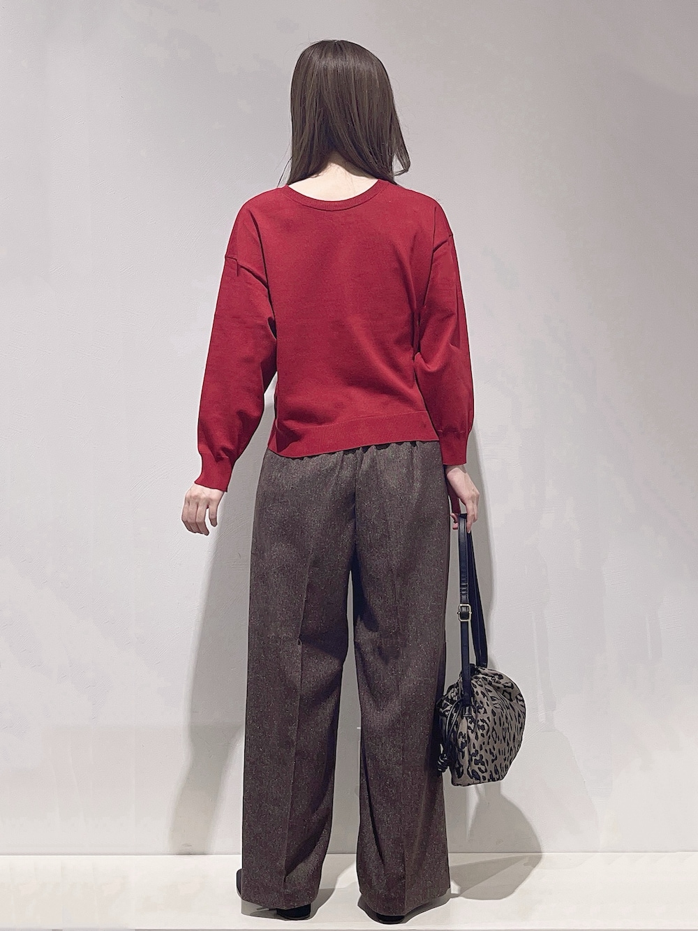 レッド系のカーディガン/ボレロ、ブラウン系のその他パンツ、ブラウン系のショルダーバッグを着用したレディースの秋コーディネートの3枚目の写真