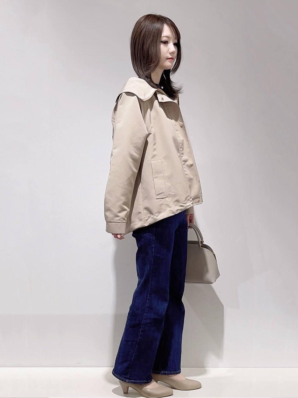 ベージュ系のブルゾン、ブルー系のカーディガン/ボレロ、ホワイト系のTシャツ/カットソーを着用したレディースの春コーディネートの2枚目の写真
