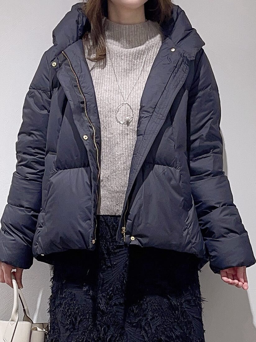 ブラック系のダウンジャケット/コート、ベージュ系のニット/セーター、ブラック系のスカートを着用したレディースの冬コーディネートの4枚目の写真
