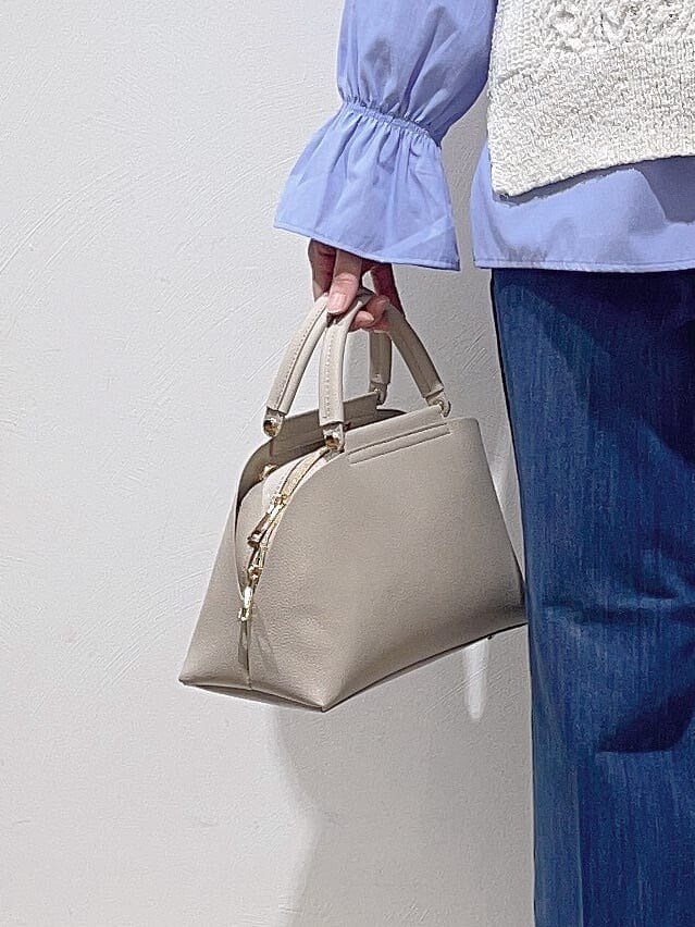 ホワイト系のニット/セーター、ブルー系のシャツ/ブラウス、ブルー系のデニムパンツを着用したレディースの冬コーディネートの10枚目の写真