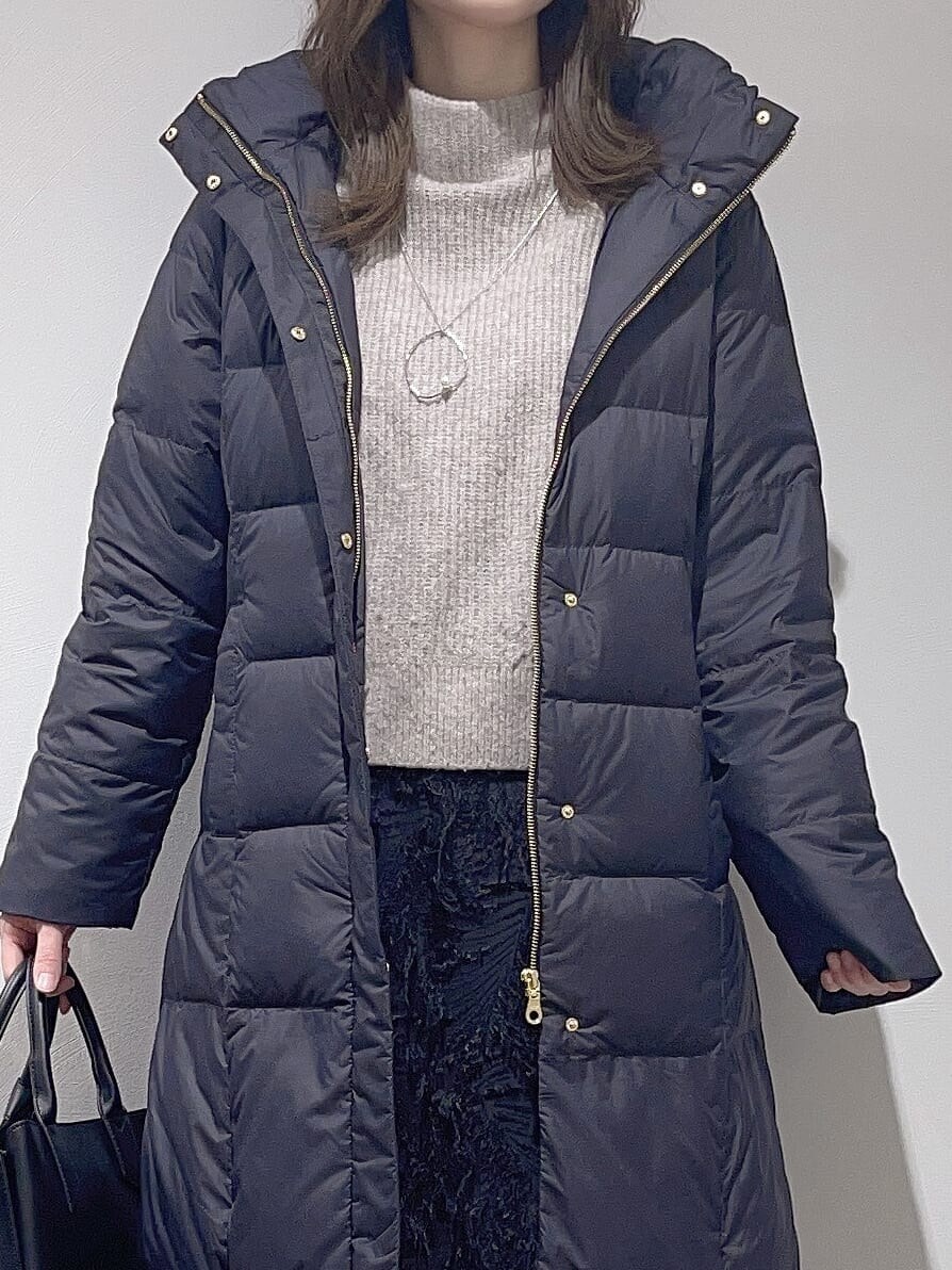 ブルー系のダウンジャケット/コート、ベージュ系のニット/セーター、ブラック系のスカートを着用したレディースの冬コーディネートの5枚目の写真