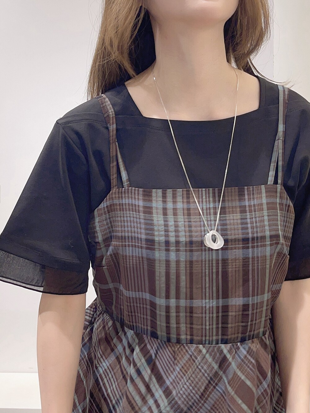 ブラウン系のワンピース、ブラック系のTシャツ/カットソー、ブラック系のトートバッグを着用したレディースの春コーディネートの7枚目の写真