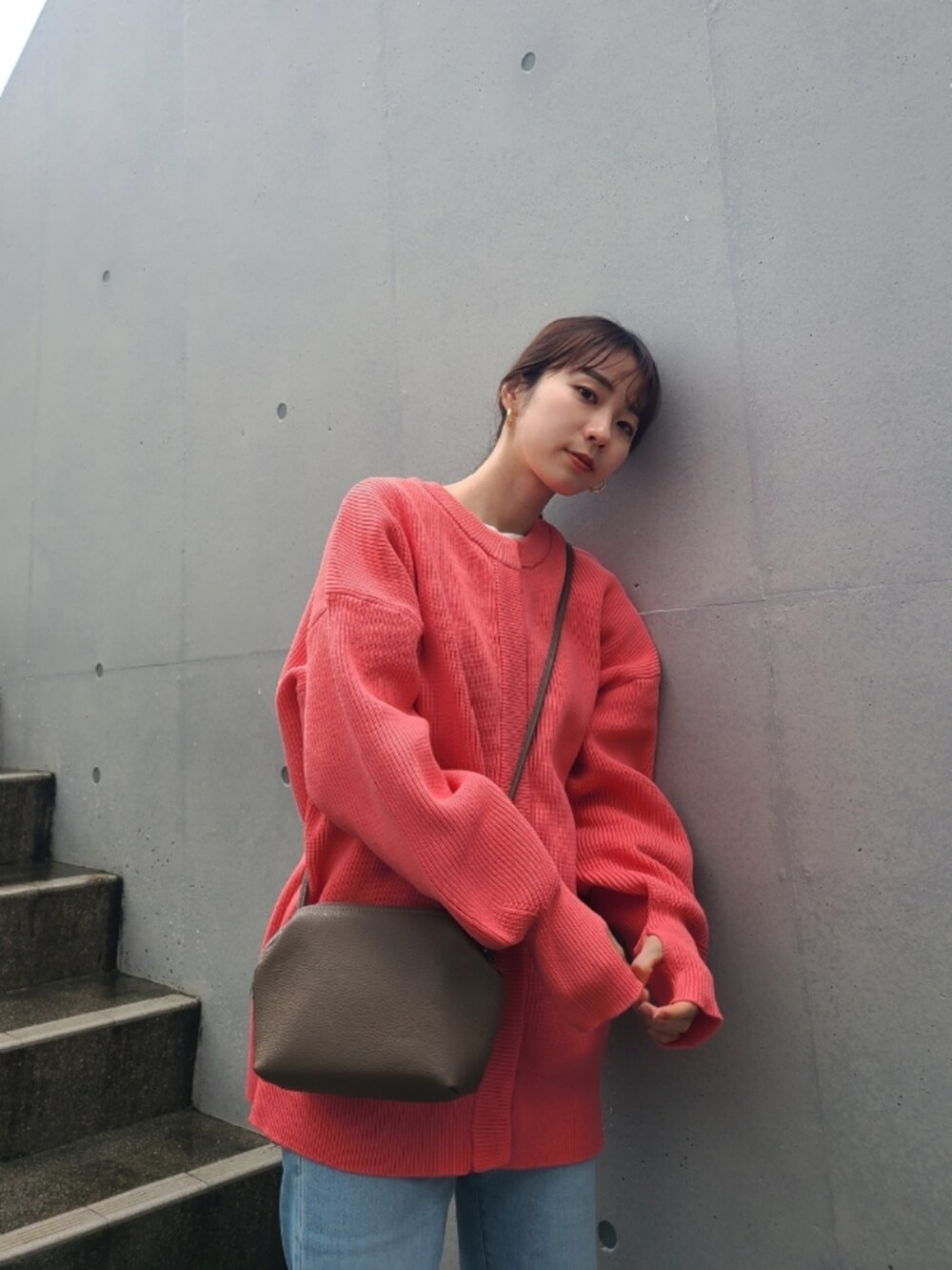 ブルー系のデニムパンツ、ホワイト系のスニーカー、ピンク系のカーディガン/ボレロを着用したレディースの冬コーディネートの3枚目の写真