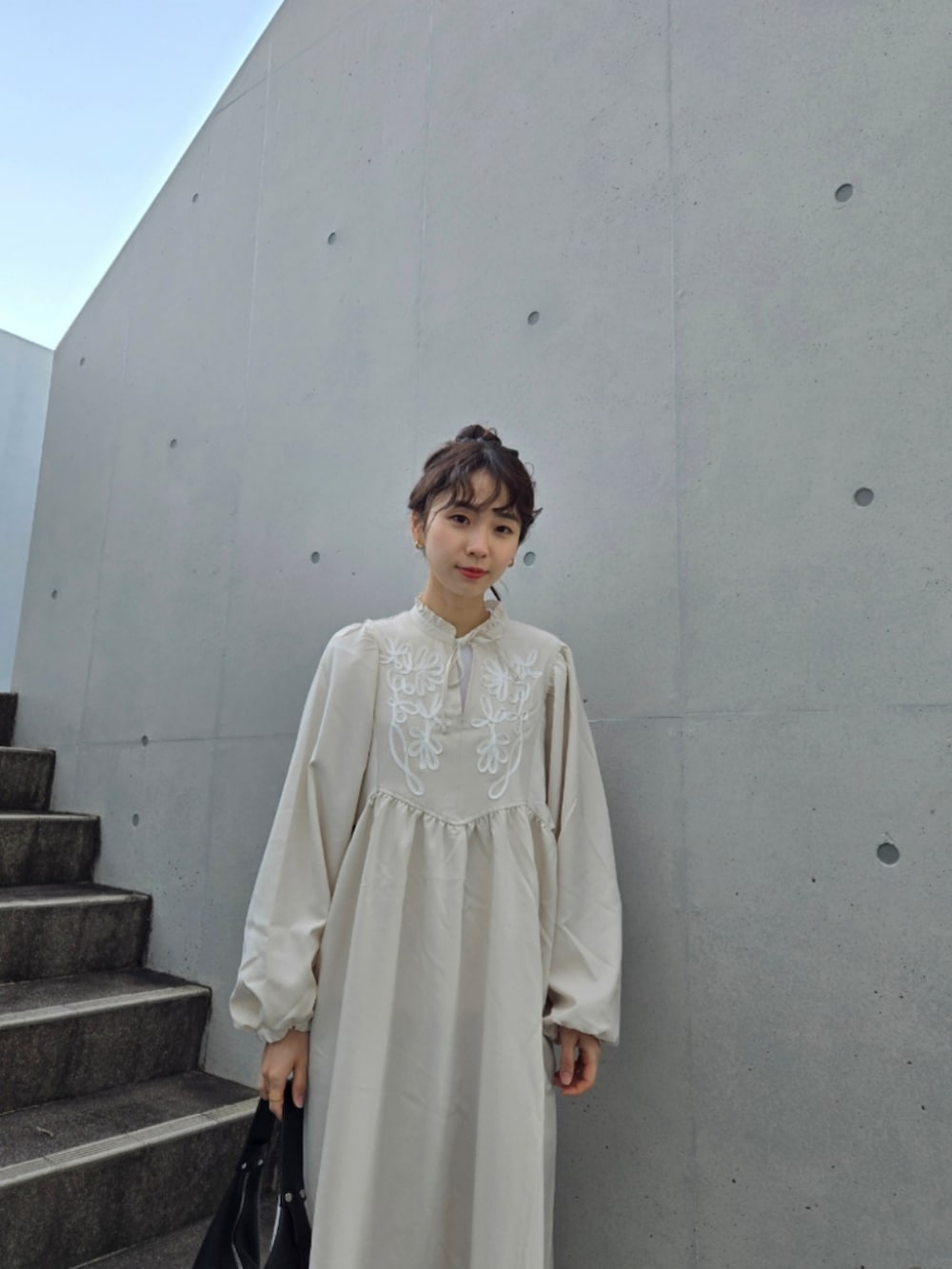 ホワイト系のワンピース、グリーン系のテーラードジャケット、ブラック系のブーツを着用したレディースの冬コーディネートの4枚目の写真