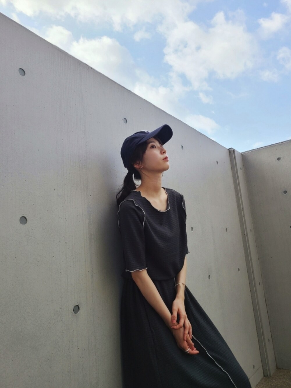 グレー系のTシャツ/カットソー、グレー系のスカート、ブルー系のスニーカーを着用したレディースの春コーディネートの4枚目の写真