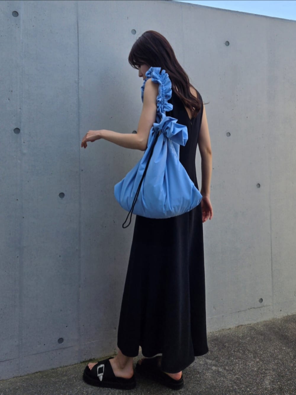 ブルー系のショルダーバッグ、ブラック系のサンダル、ブラック系のワンピースを着用したレディースの春コーディネートの4枚目の写真
