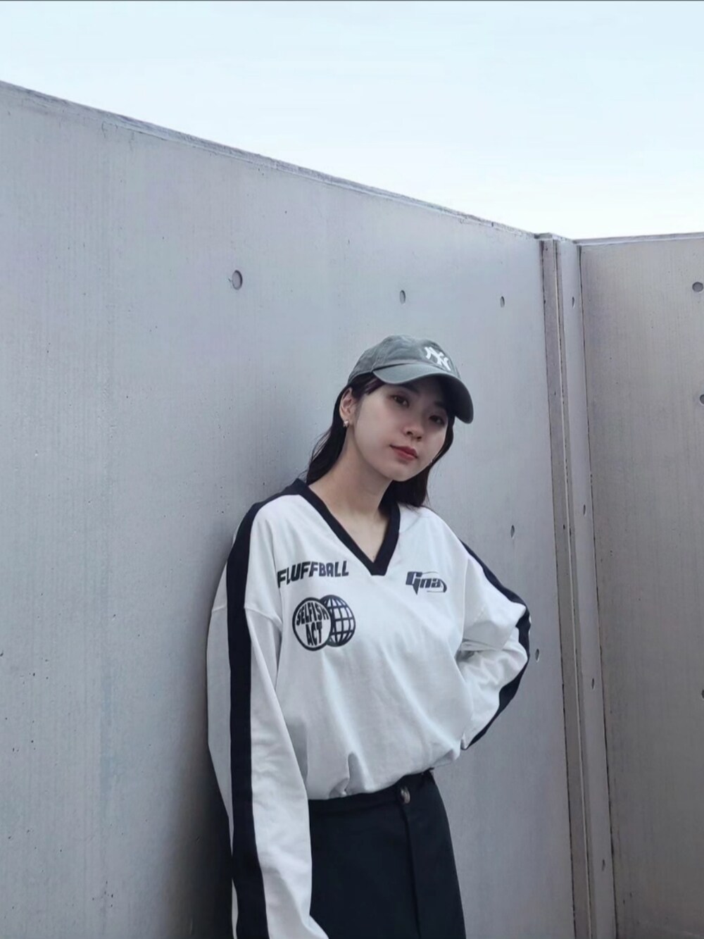 ホワイト系のハンドバッグ、ホワイト系のTシャツ/カットソー、グリーン系のキャップを着用したレディースの春コーディネートの2枚目の写真