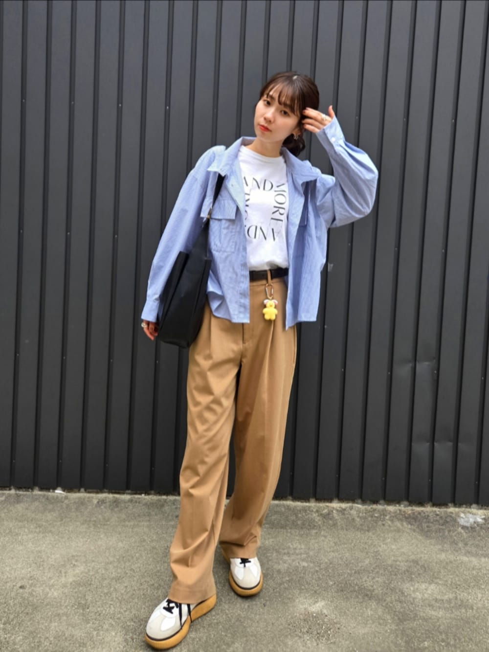 ベージュ系のパンツ、ブラック系のトートバッグ、ホワイト系のTシャツ/カットソーを着用したレディースの秋コーディネートの5枚目の写真