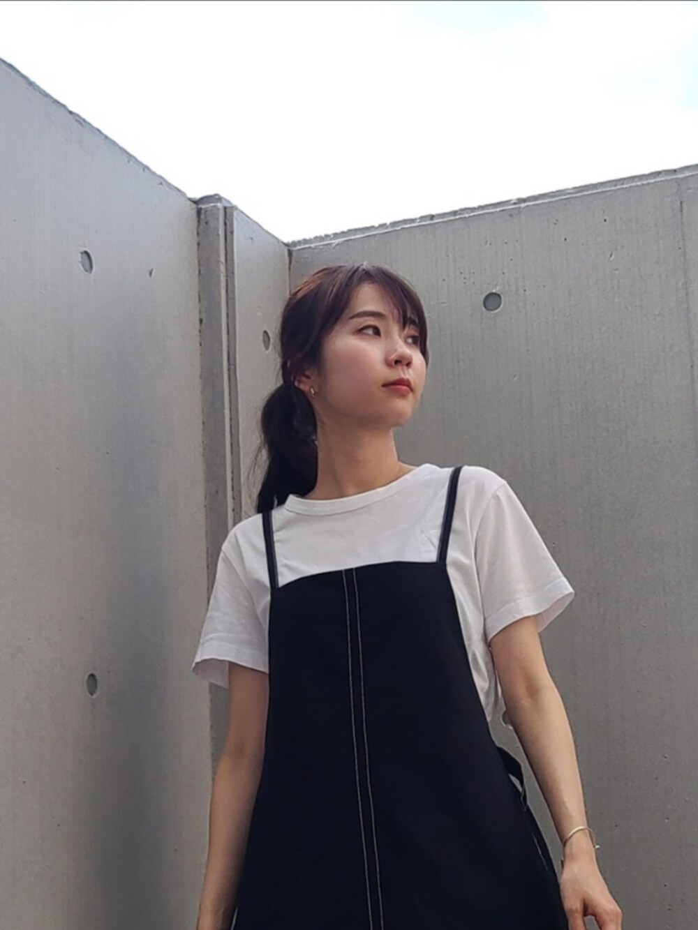 ブラック系のワンピース、グリーン系のスニーカー、シルバー系のピアス（両耳用）を着用したレディースの夏コーディネートの3枚目の写真