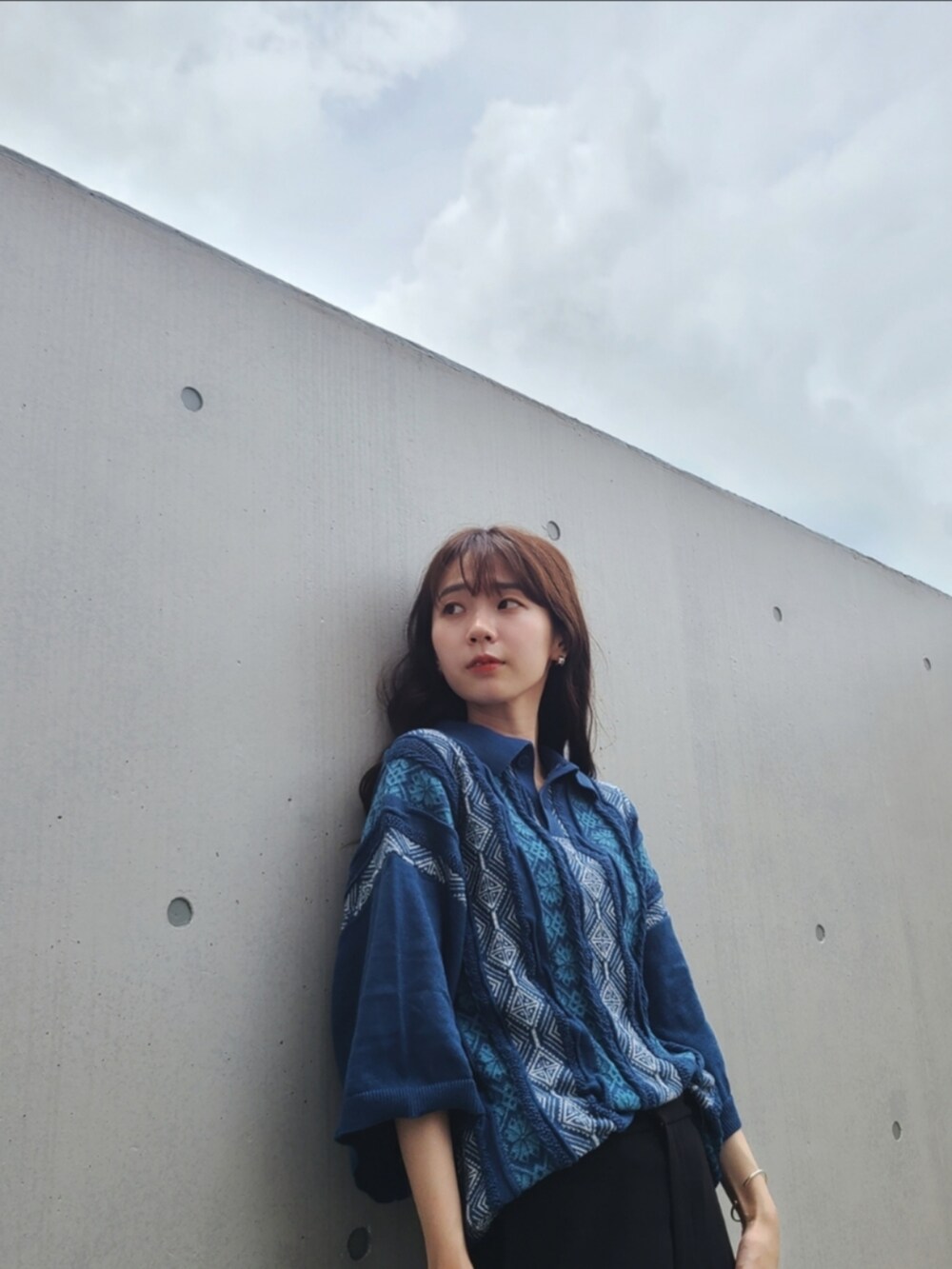 ブルー系のポロシャツ、ブラック系のパンツ、ブラック系のサンダルを着用したレディースの夏コーディネートの2枚目の写真