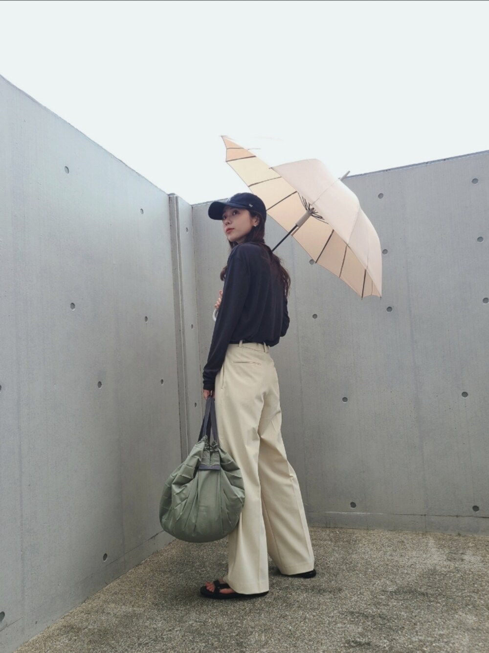 ホワイト系のバッグ、ホワイト系のパンツ、ブラック系のサンダルを着用したレディースの夏コーディネートの3枚目の写真