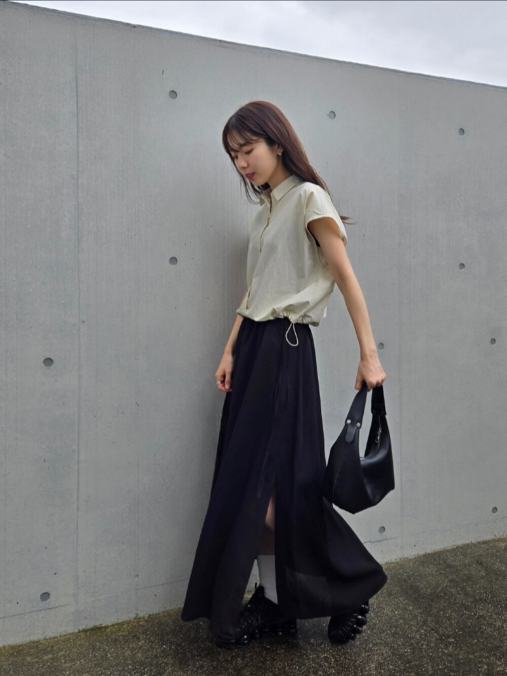 ブラック系のスニーカー、ブラック系のスカート、ホワイト系のシャツ/ブラウスを着用したレディースの春コーディネートの3枚目の写真