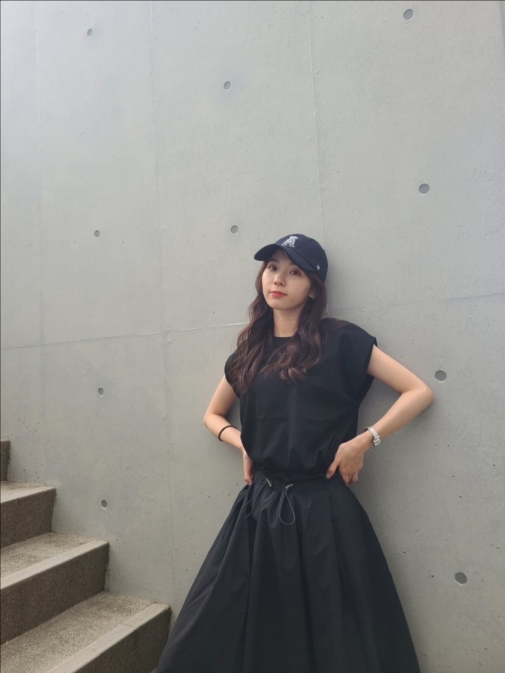 ブラック系のTシャツ/カットソー、ブラック系のスカート、ブラック系のスニーカーを着用したレディースの夏コーディネートの4枚目の写真