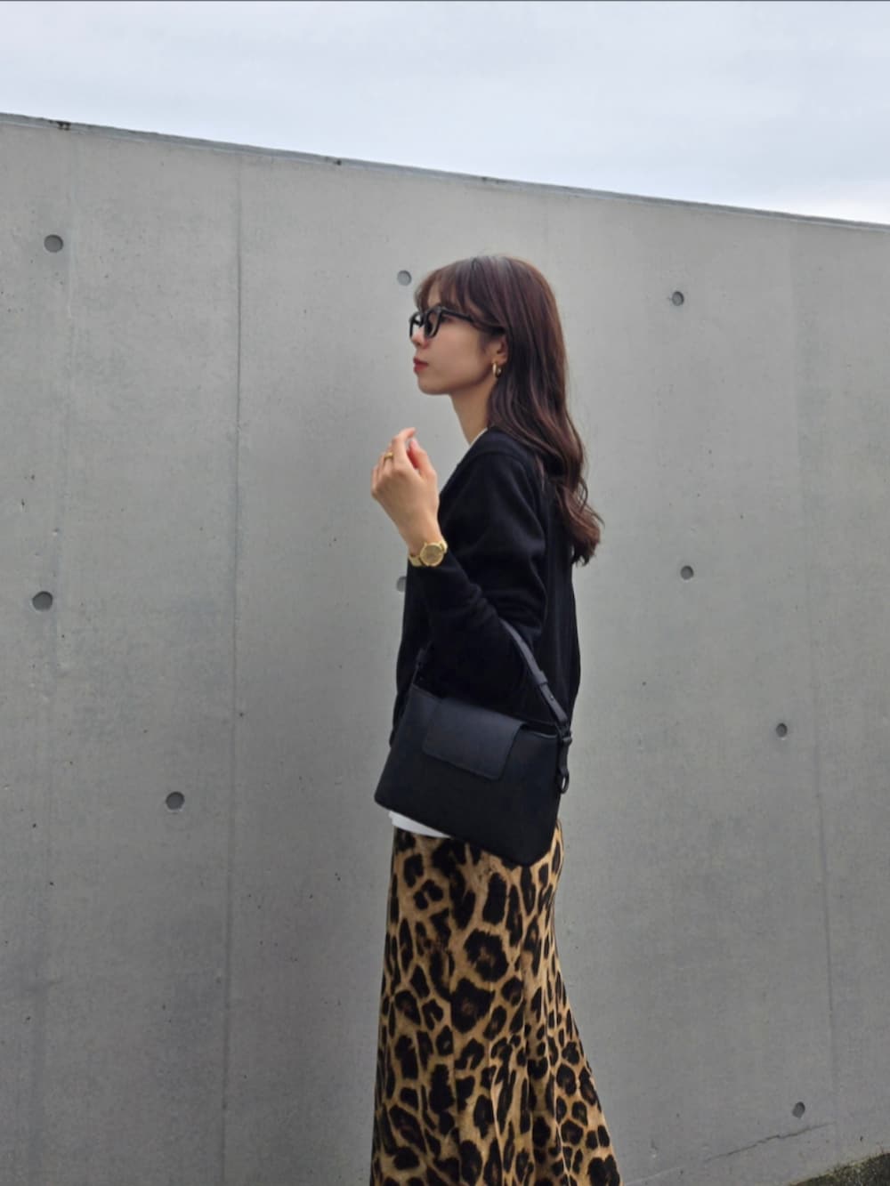 ブラック系のカーディガン/ボレロ、ブラック系のショルダーバッグ、ブラック系のブーツを着用したレディースの秋コーディネートの4枚目の写真