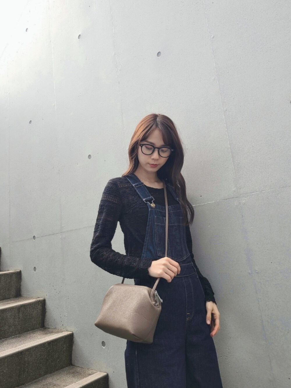 ブルー系のサロペット/オーバーオール、ブラウン系のボストンバッグ、ブラック系のブーツを着用したレディースの冬コーディネートの3枚目の写真