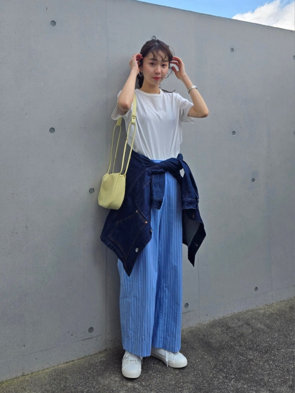 ホワイト系のTシャツ/カットソー、ブルー系のパンツ、イエロー系のショルダーバッグを着用したレディースの春コーディネートの3枚目の写真