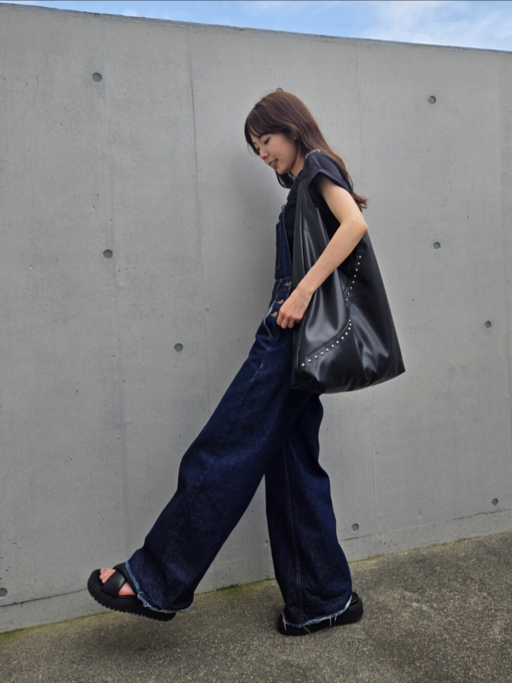 ブラック系のトートバッグ、ブルー系のサロペット/オーバーオール、ブラック系のサンダルを着用したレディースの夏コーディネートの4枚目の写真
