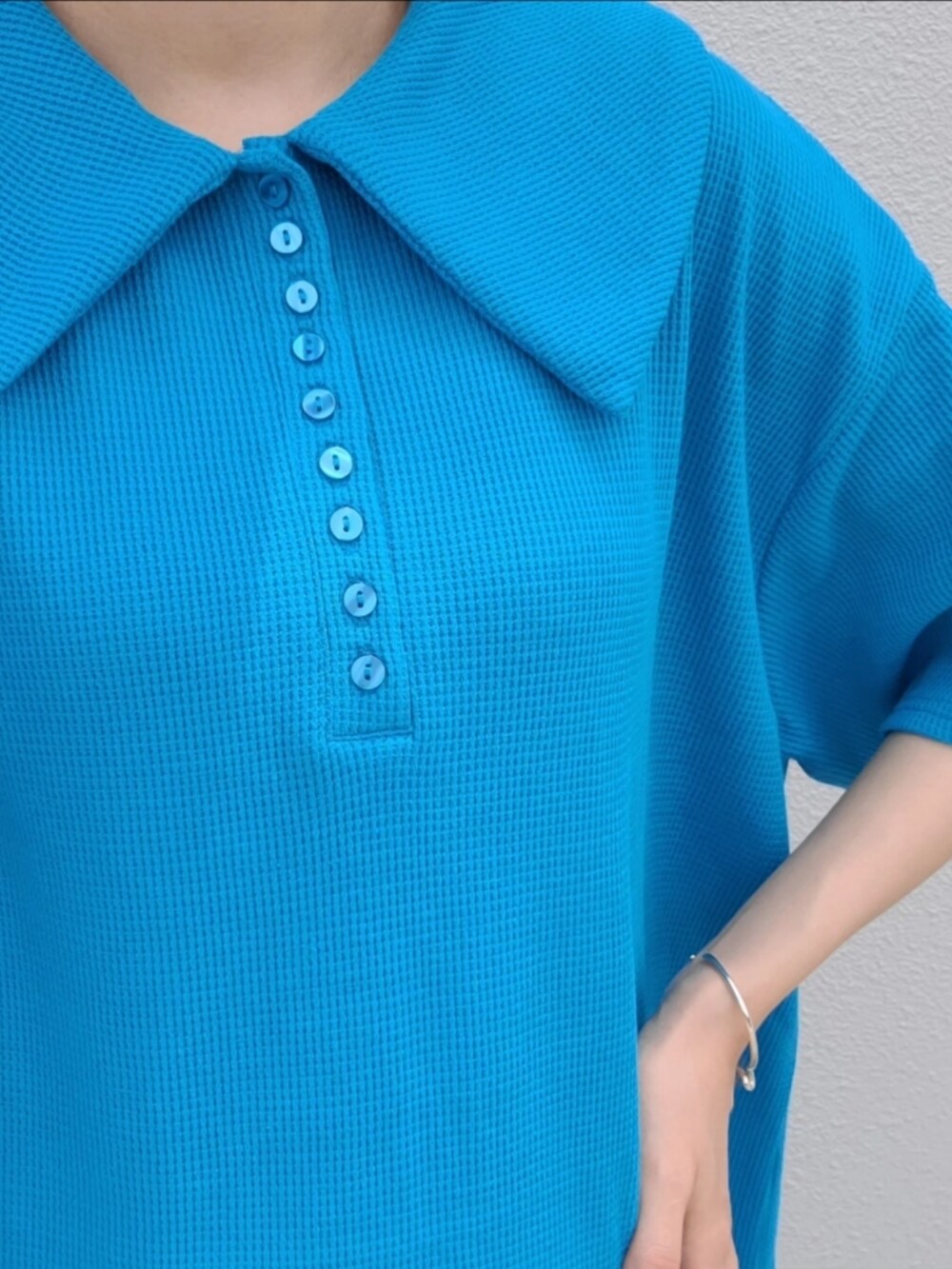 ブラック系のスニーカー、ブルー系のワンピースを着用したレディースの春コーディネートの2枚目の写真