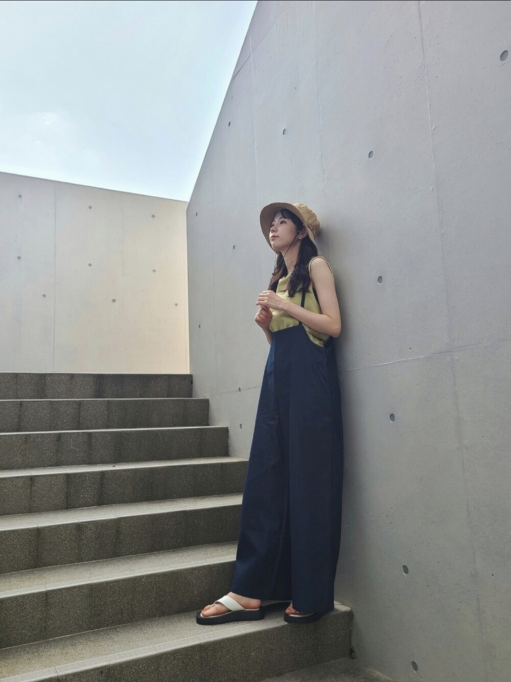 ブルー系のサロペット/オーバーオール、グリーン系のトップス、ホワイト系のサンダルを着用したレディースの春コーディネートの2枚目の写真