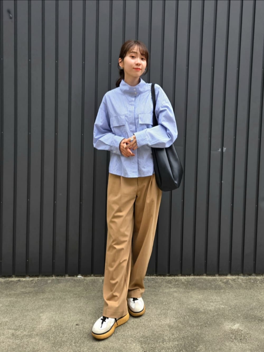 ベージュ系のパンツ、ブラック系のトートバッグ、ホワイト系のTシャツ/カットソーを着用したレディースの秋コーディネートの4枚目の写真