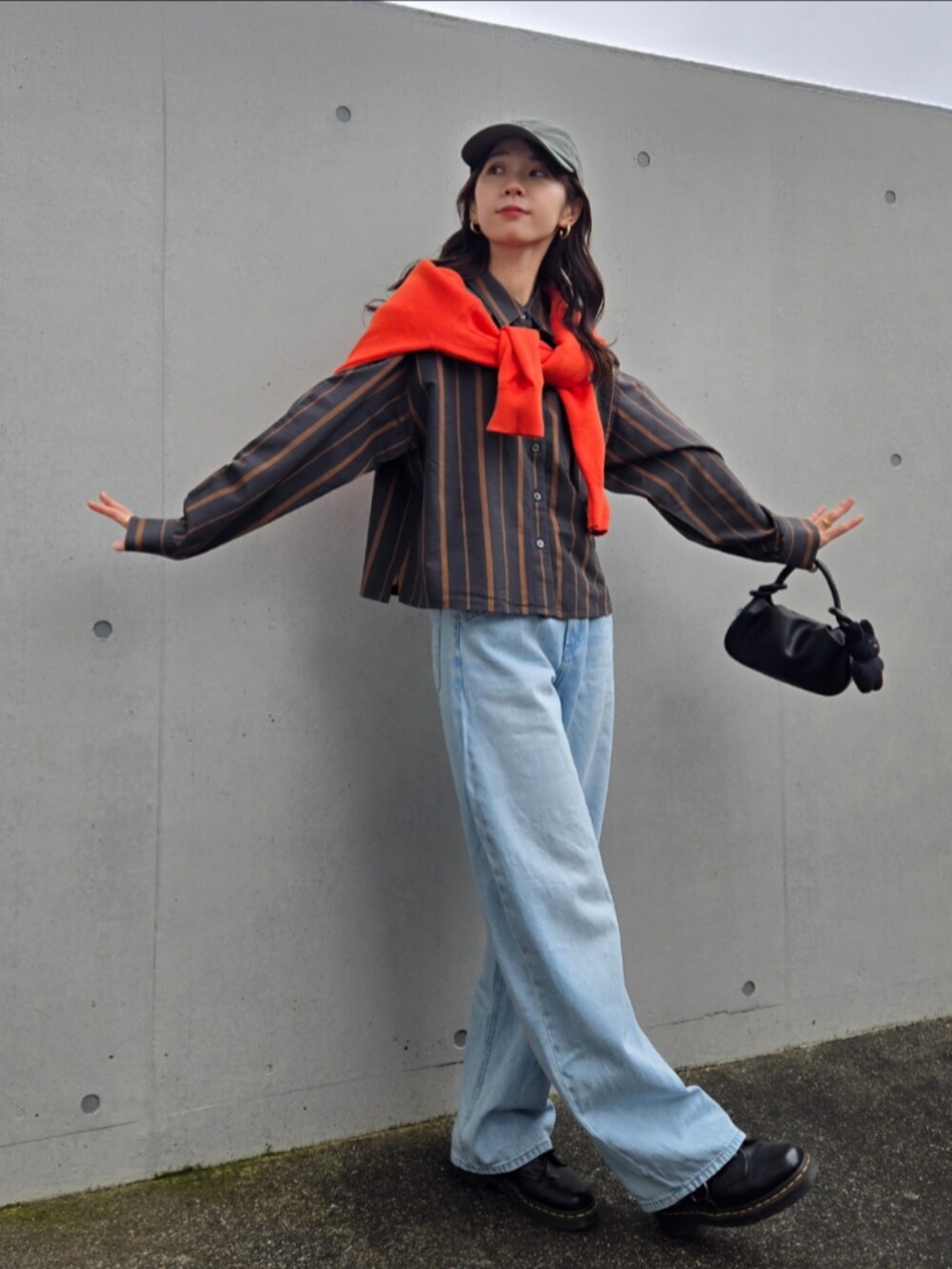 ブルー系のデニムパンツ、グレー系のシャツ/ブラウス、ブラック系のブーツを着用したレディースの秋コーディネートの3枚目の写真
