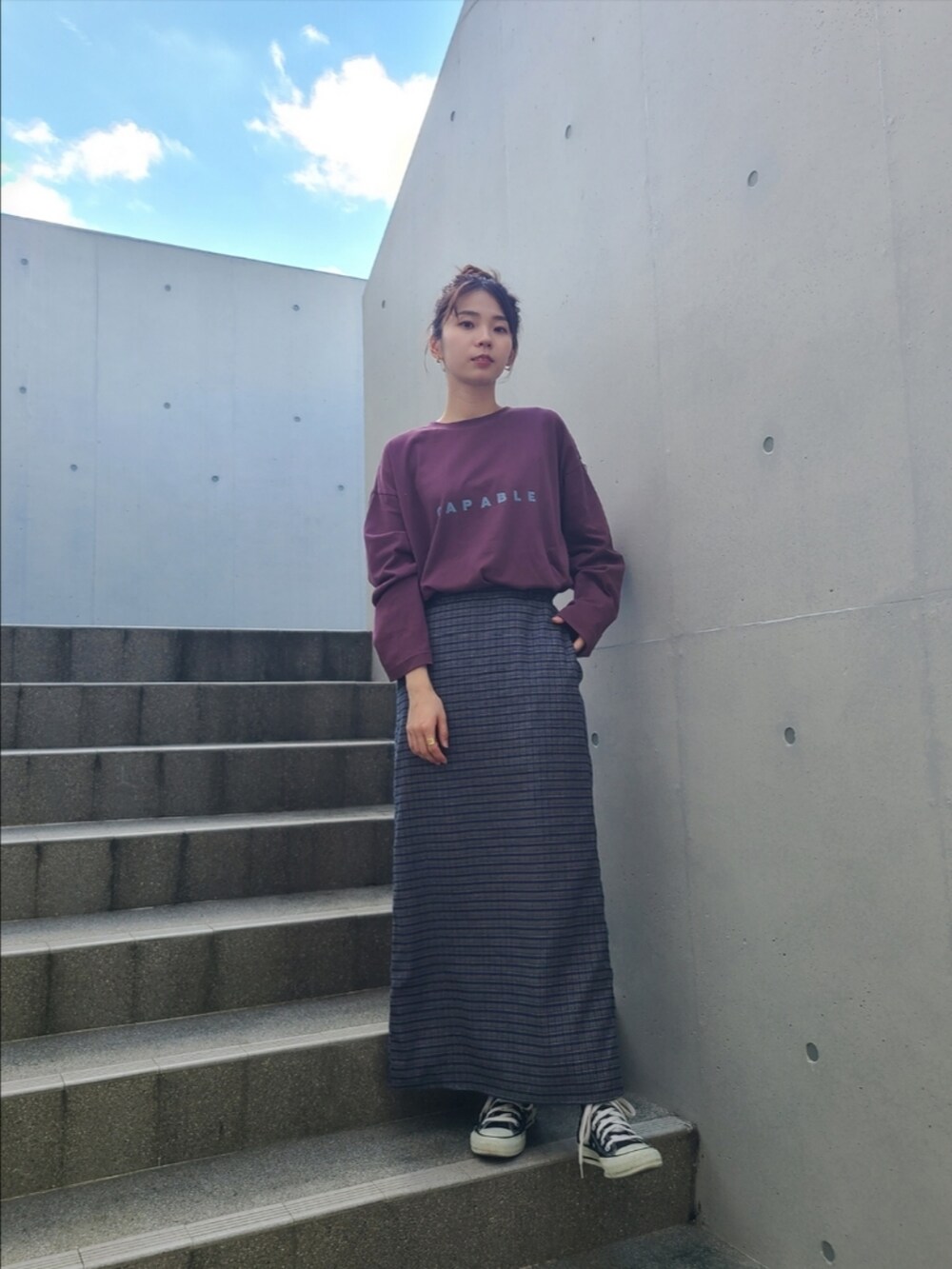 レッド系のTシャツ/カットソー、ブルー系のデニムジャケット、ブルー系のスカートを着用したレディースの秋コーディネートの2枚目の写真