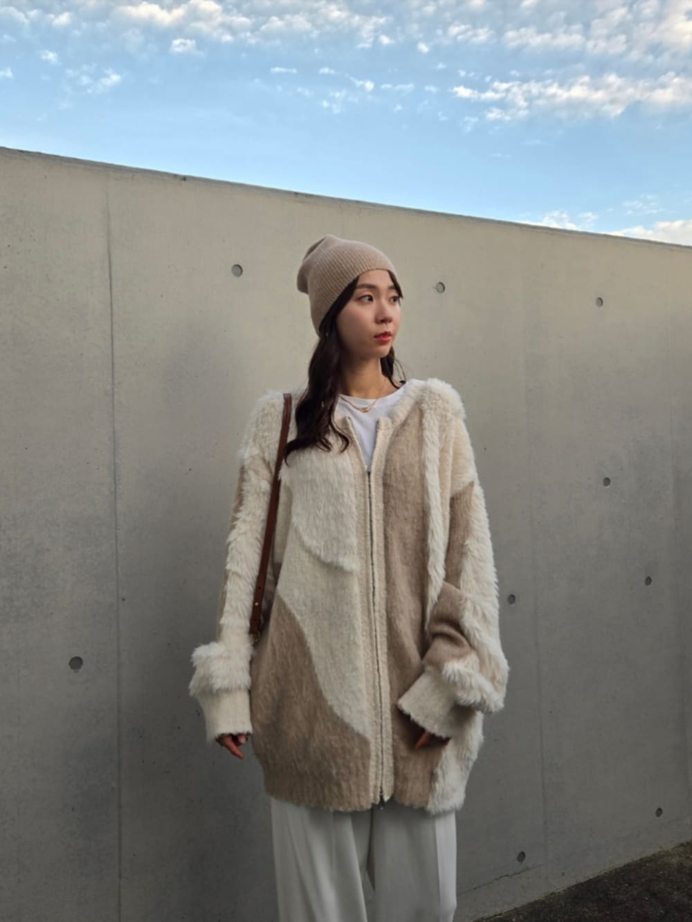 ベージュ系のカーディガン/ボレロ、ホワイト系のパンツ、ホワイト系のブーツを着用したレディースの秋コーディネートの5枚目の写真