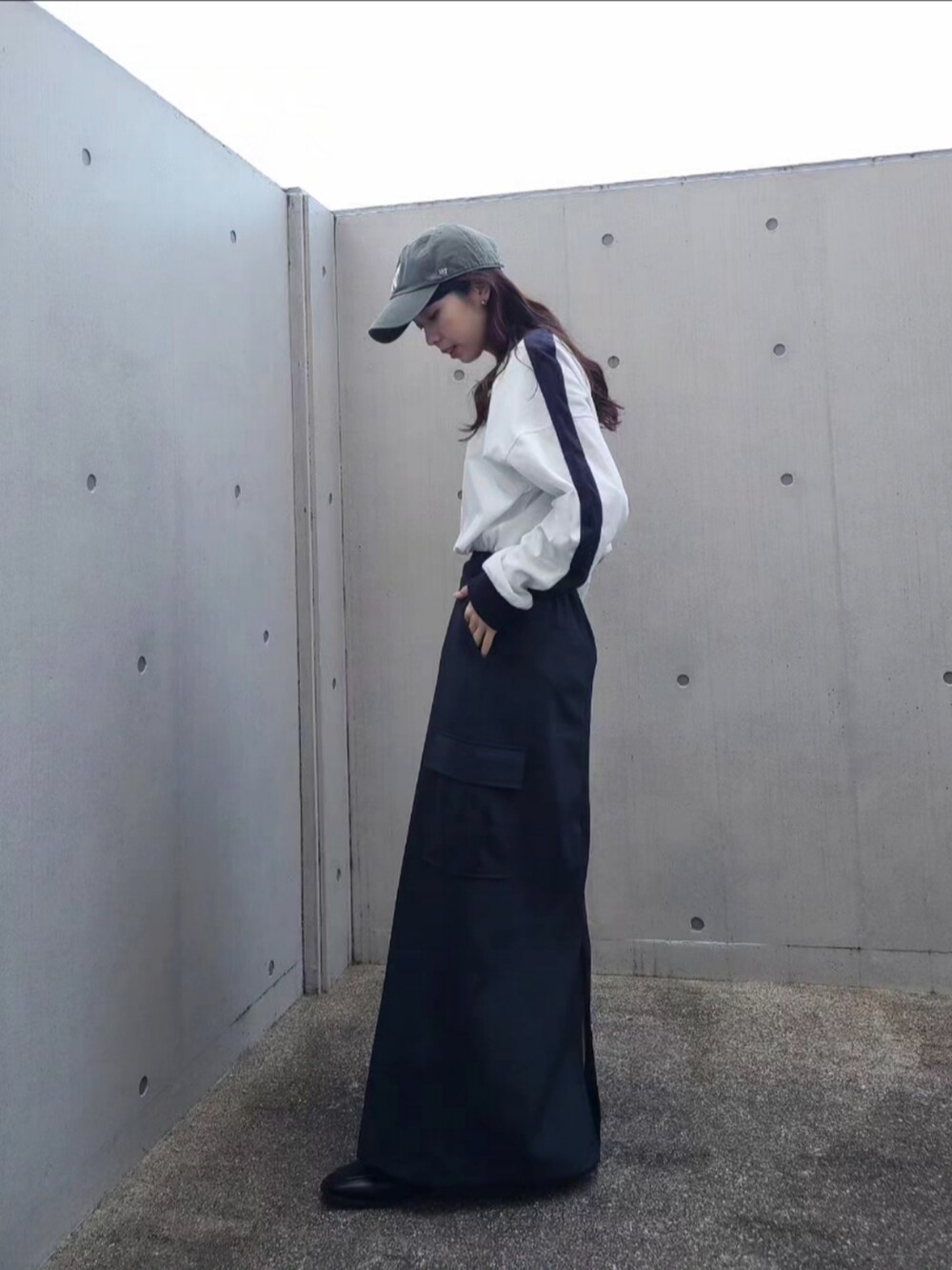 ホワイト系のハンドバッグ、ホワイト系のTシャツ/カットソー、グリーン系のキャップを着用したレディースの春コーディネートの3枚目の写真