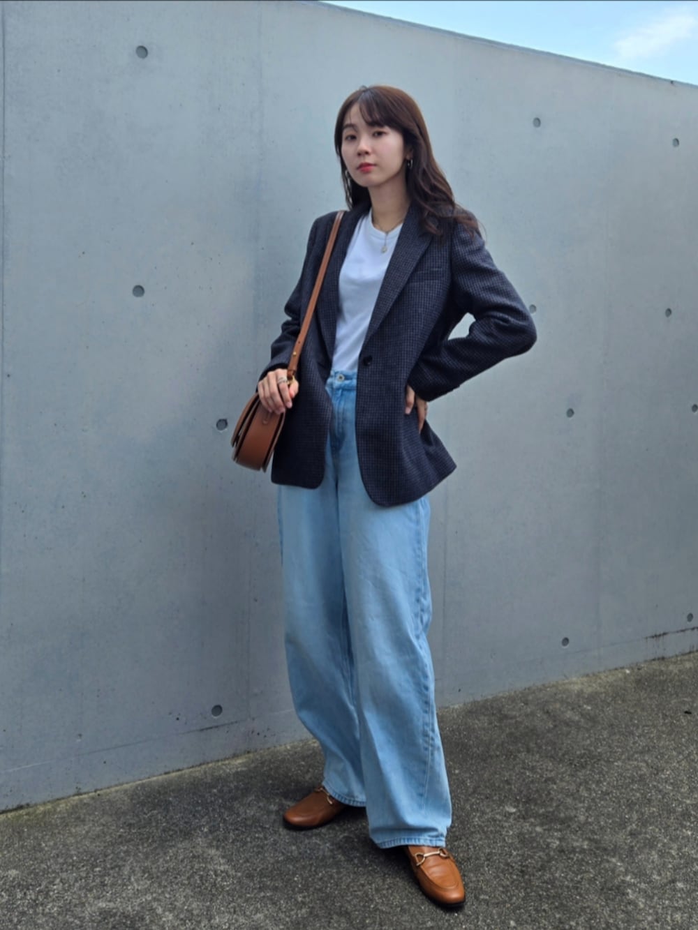 グレー系のテーラードジャケット、ブルー系のデニムパンツ、ブラウン系のシューズを着用したレディースの秋コーディネートの4枚目の写真