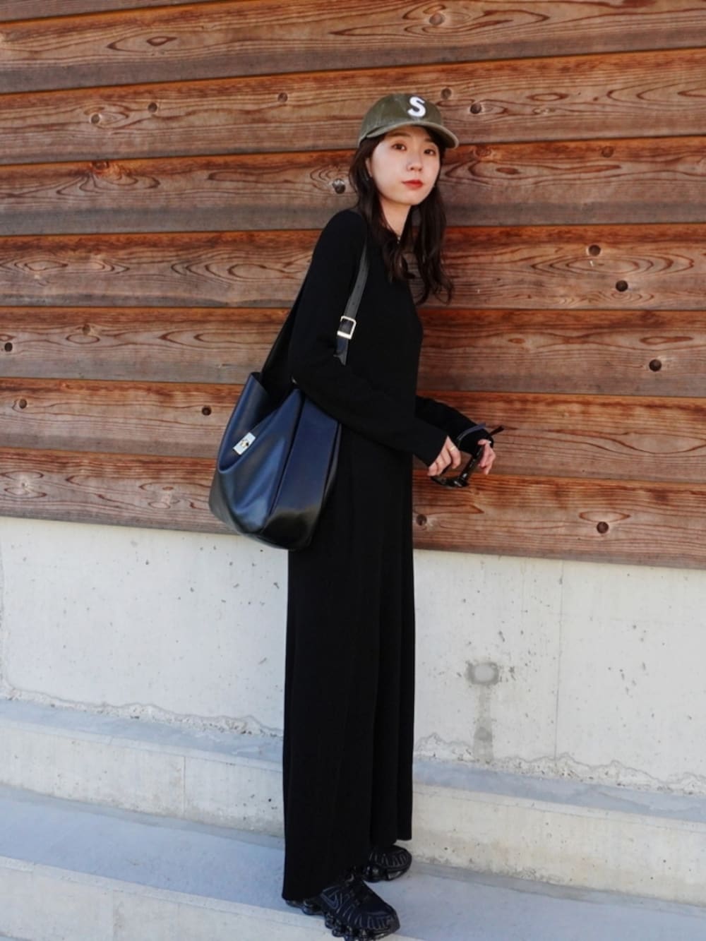 ブラック系のスニーカー、ブラック系のトートバッグ、グリーン系のキャップを着用したレディースの秋コーディネートの2枚目の写真