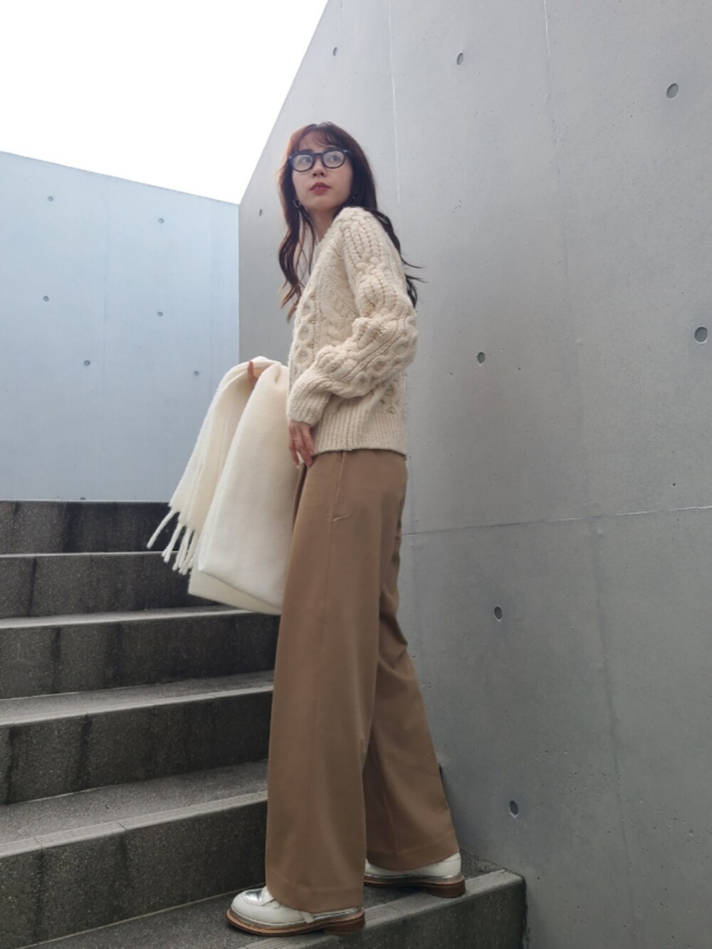ホワイト系のニット/セーター、ベージュ系のパンツ、ホワイト系のその他シューズを着用したレディースの冬コーディネートの2枚目の写真