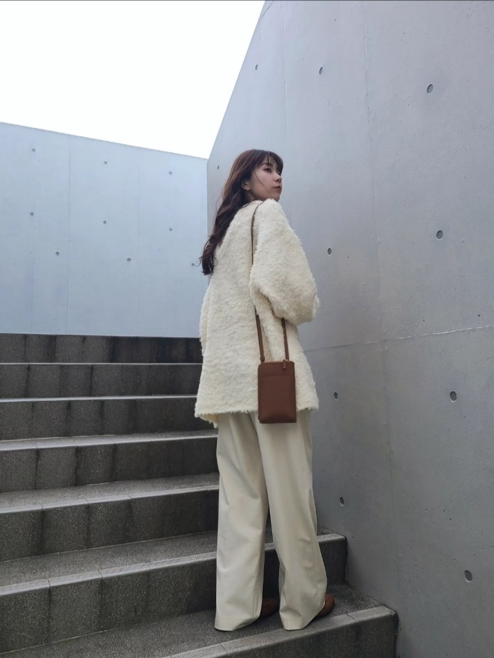 ホワイト系のニット/セーター、ブラウン系のシューズ、ゴールド系のピアス（両耳用）を着用したレディースの秋コーディネートの3枚目の写真