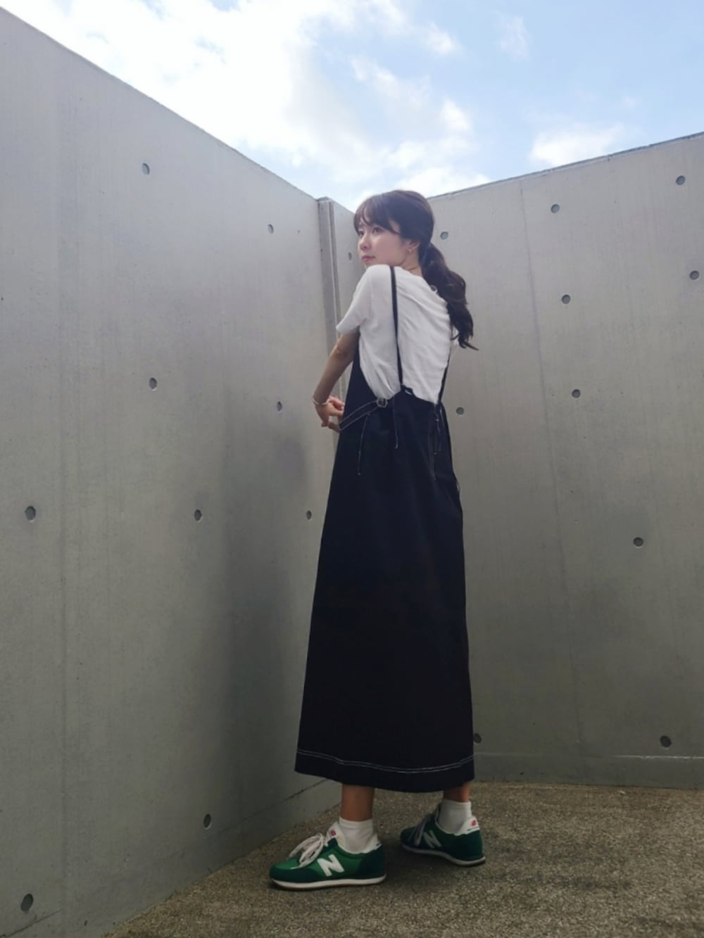 ブラック系のワンピース、グリーン系のスニーカー、シルバー系のピアス（両耳用）を着用したレディースの夏コーディネートの2枚目の写真