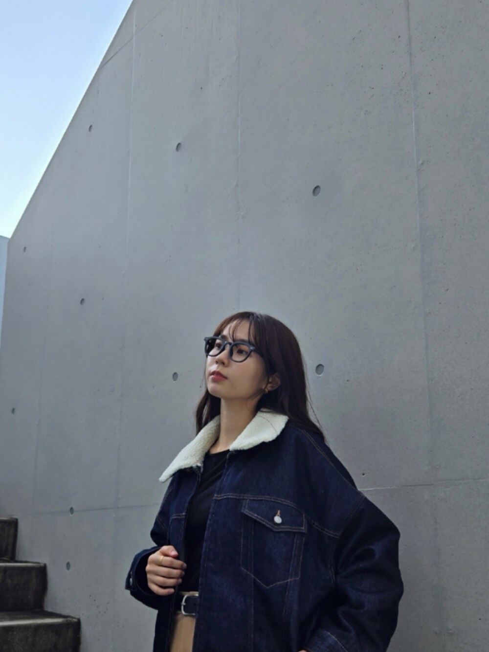 ブルー系のデニムジャケット、ベージュ系のパンツ、ブラック系のブーツを着用したレディースの秋コーディネートの4枚目の写真