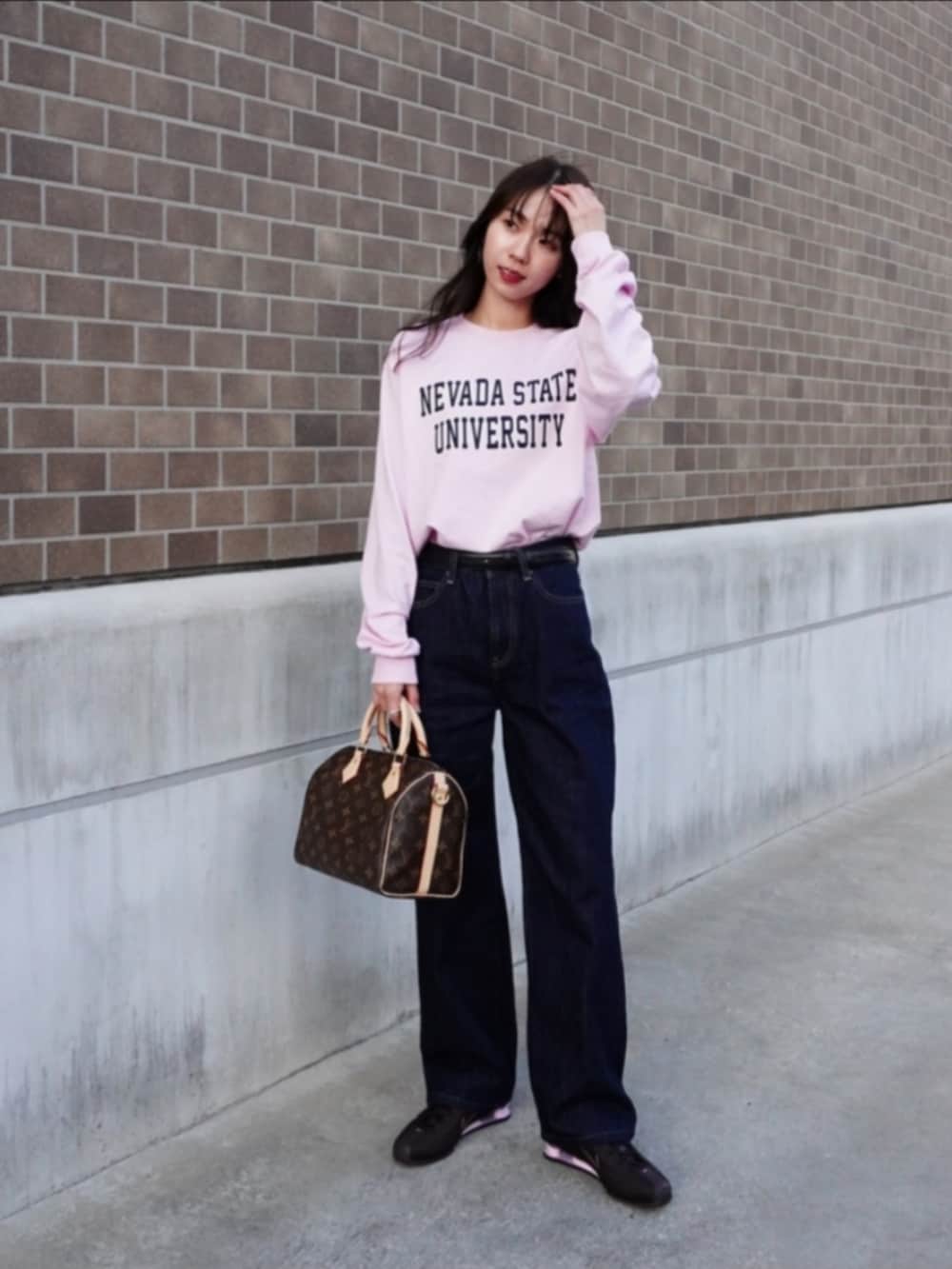 ブラウン系のスニーカー、ブルー系のデニムパンツ、ピンク系のTシャツ/カットソーを着用したレディースの冬コーディネートの4枚目の写真