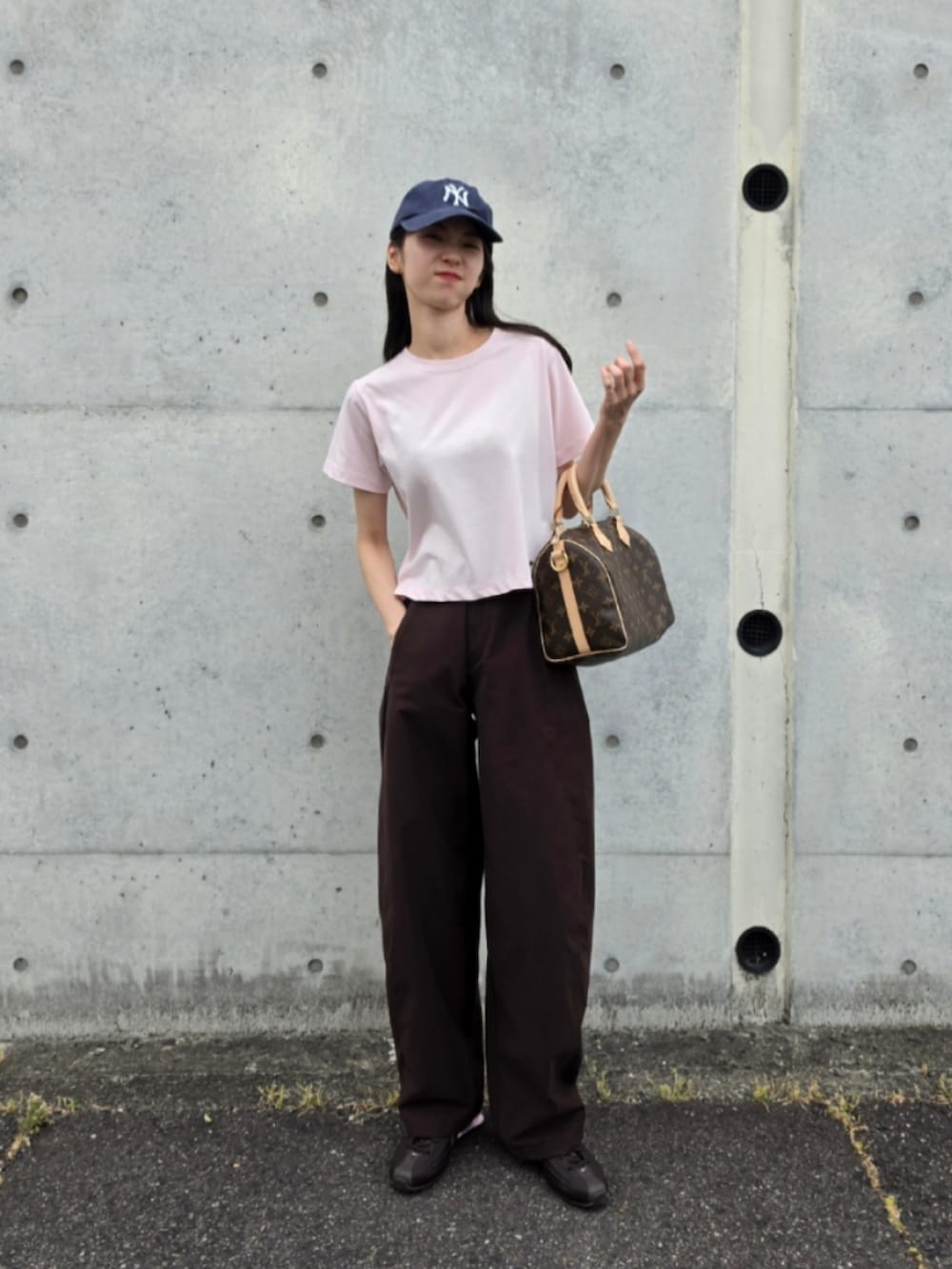 ピンク系のTシャツ/カットソー、ブラウン系のボストンバッグ、ブラウン系のパンツを着用したレディースの夏コーディネートの4枚目の写真