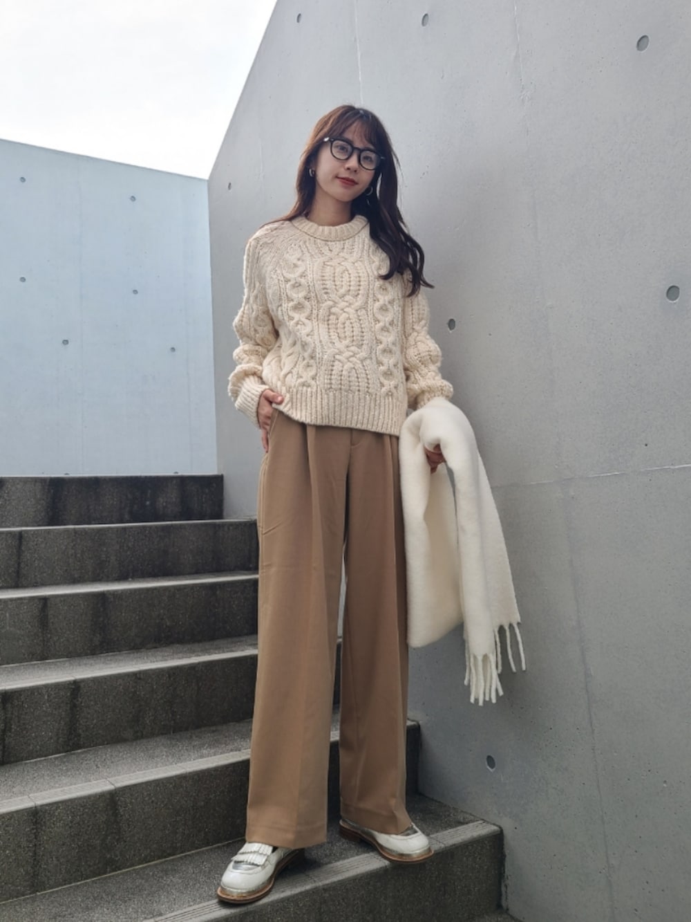 ホワイト系のニット/セーター、ベージュ系のパンツ、ホワイト系のその他シューズを着用したレディースの冬コーディネートの3枚目の写真