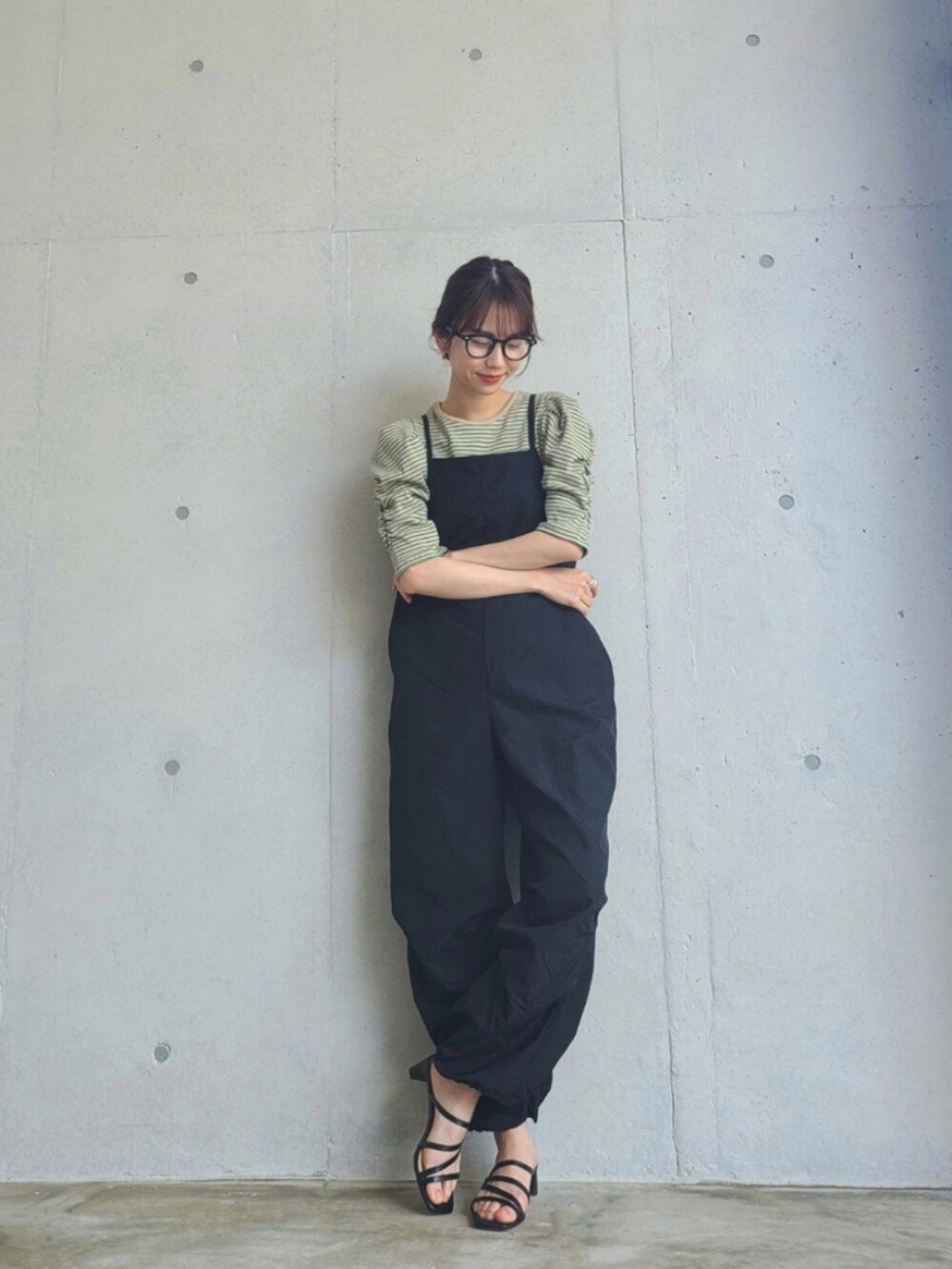 ブラック系のサロペット/オーバーオール、グリーン系のTシャツ/カットソーを着用したレディースの春コーディネートの2枚目の写真