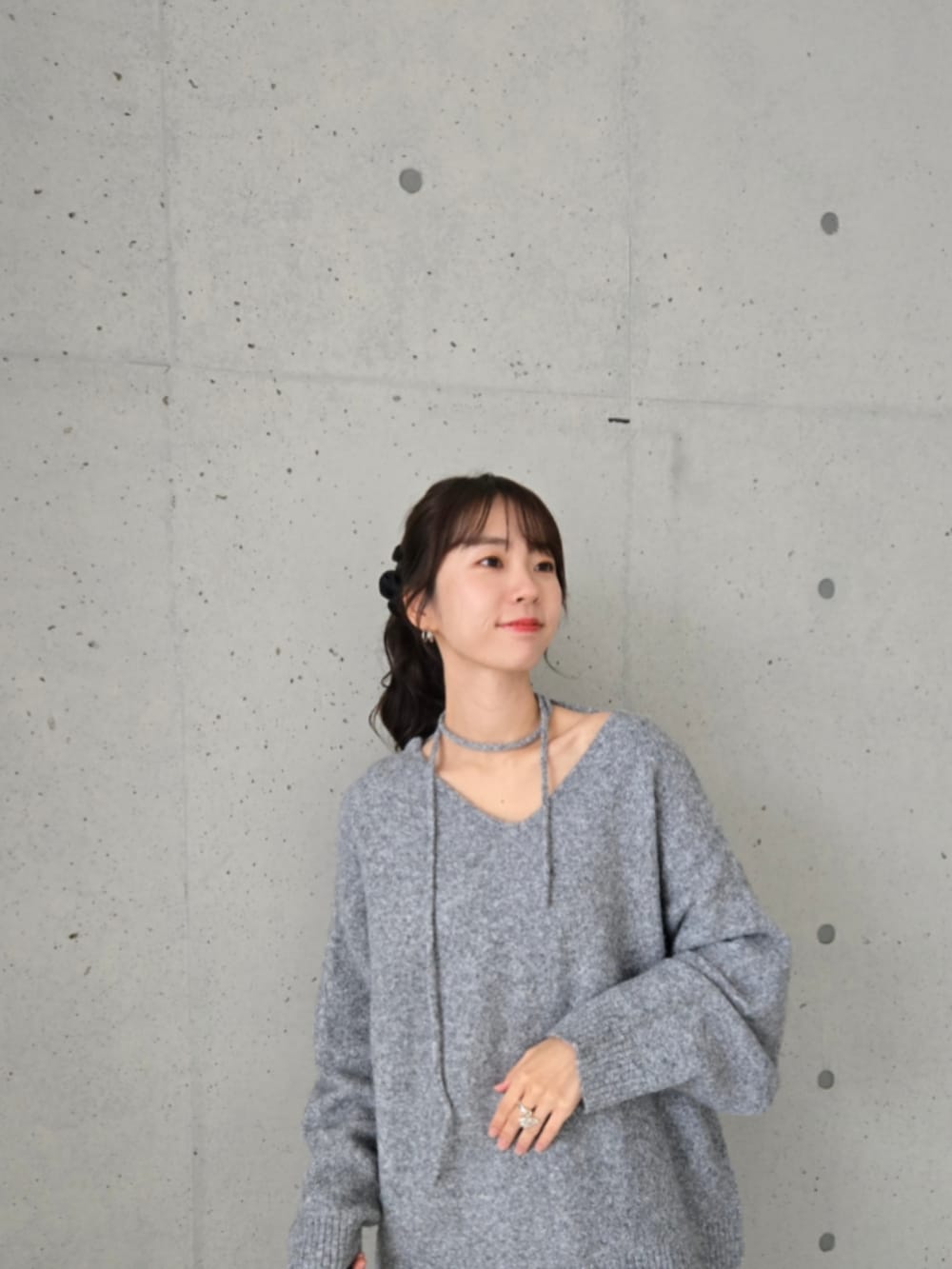 グレー系のニット/セーター、ブルー系のショルダーバッグ、ブラウン系のスウェットパンツを着用したレディースの秋コーディネートの3枚目の写真