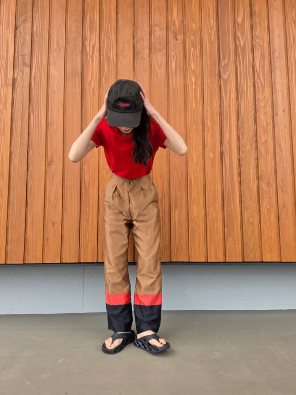 ブラウン系のその他パンツ、ブラック系のサンダル、レッド系のTシャツ/カットソーを着用したレディースの夏コーディネートの3枚目の写真