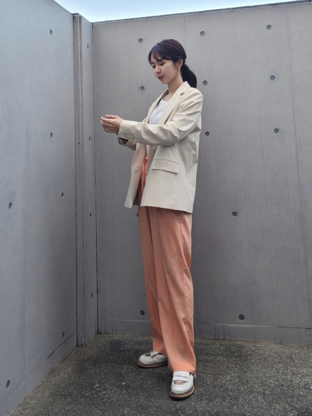 ホワイト系のテーラードジャケット、ホワイト系のその他シューズ、オレンジ系のその他パンツを着用したレディースの春コーディネートの2枚目の写真