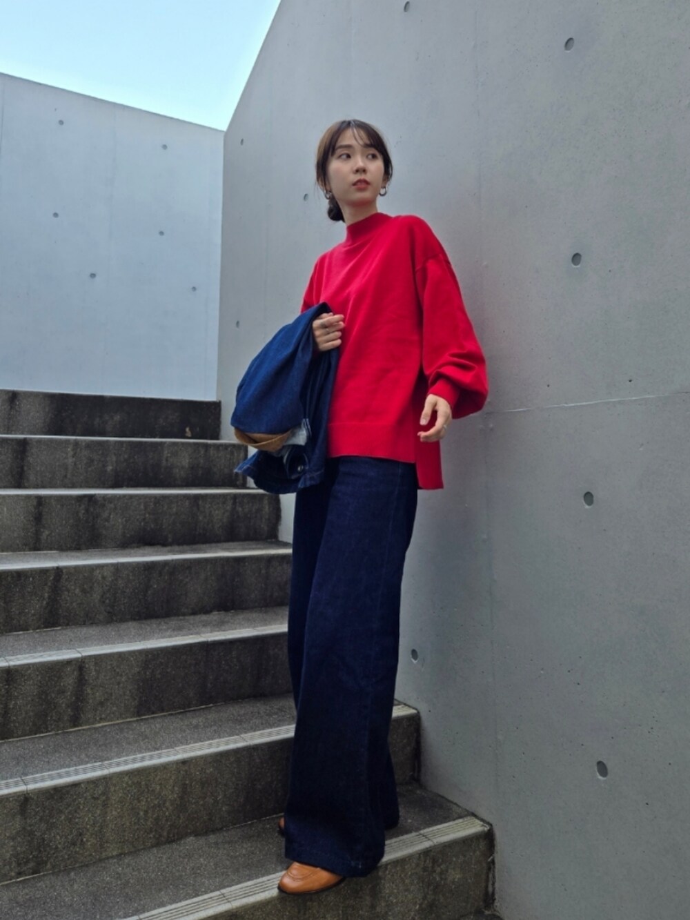 ブルー系のデニムパンツ、ブラウン系のバッグ、ブルー系のデニムジャケットを着用したレディースの秋コーディネートの4枚目の写真