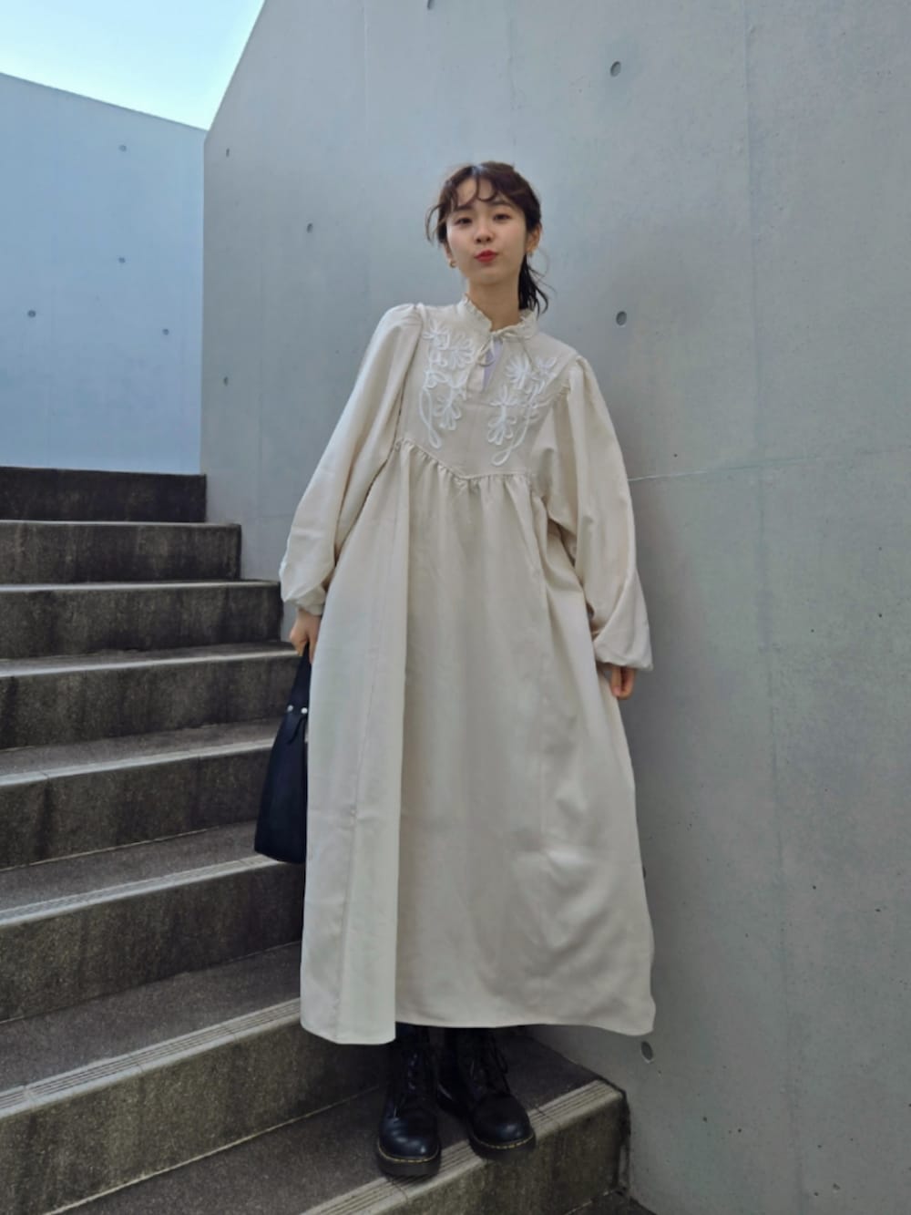 ホワイト系のワンピース、グリーン系のテーラードジャケット、ブラック系のブーツを着用したレディースの冬コーディネートの2枚目の写真