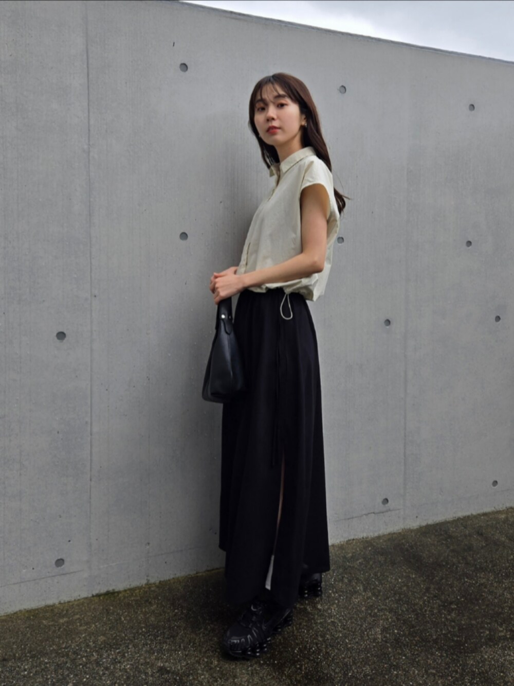 ブラック系のスニーカー、ブラック系のスカート、ホワイト系のシャツ/ブラウスを着用したレディースの春コーディネートの2枚目の写真