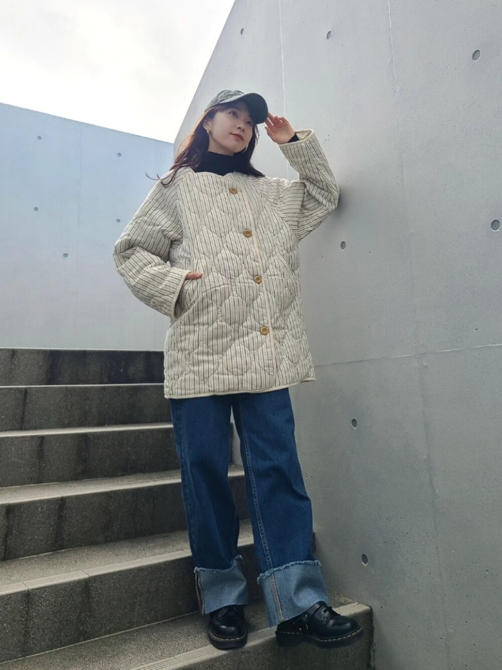 ブルー系のデニムパンツ、ブラック系のブーツ、ホワイト系のノーカラージャケットを着用したレディースの冬コーディネートの3枚目の写真