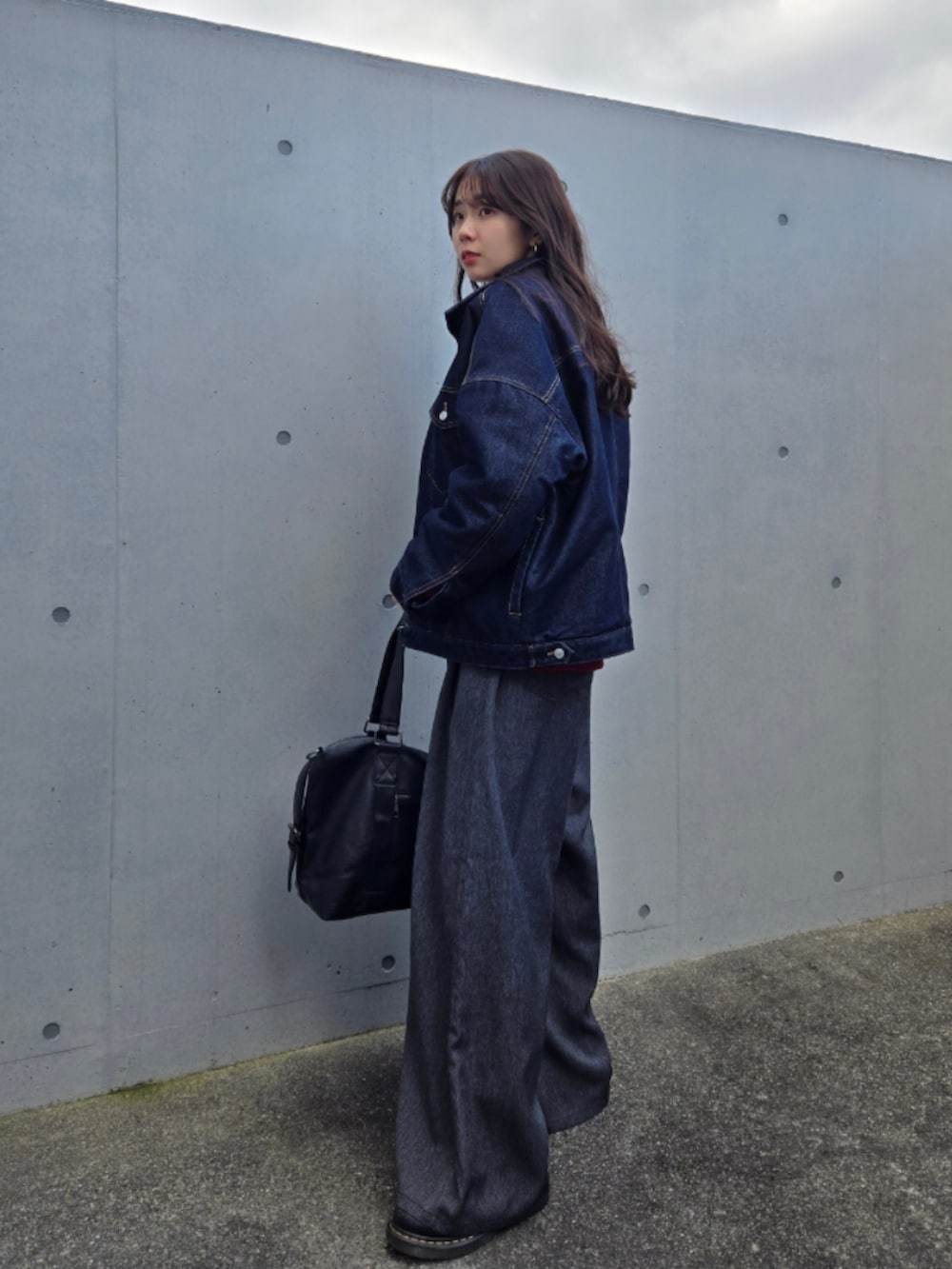 レッド系のトップス、ブルー系のデニムジャケット、ブラック系のデニムパンツを着用したレディースの冬コーディネートの4枚目の写真