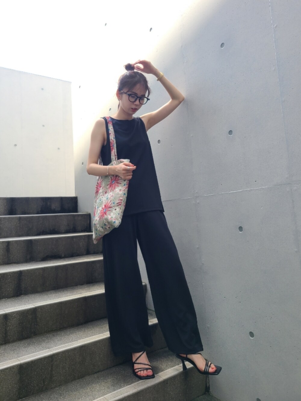 ベージュ系のショルダーバッグ、ブラック系のサンダル、ブラック系のトップスを着用したレディースの夏コーディネートの2枚目の写真